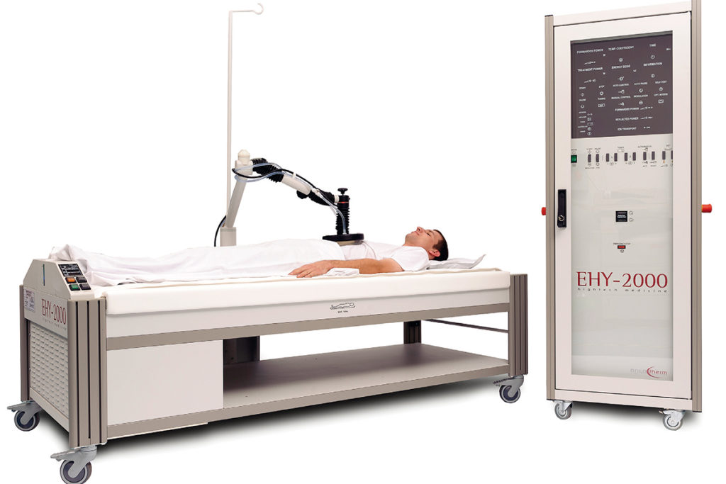 A male patient receiving Loco-Regional Hyperthermia (LRHT) treatment from a Oncotherm EHY-2000 Plus machine.